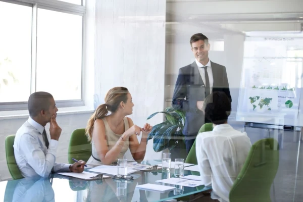 A man presents to a group of Value for Good employees, sharing insights and engaging the audience effectively.